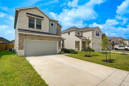 The welcoming entrance and charming landscaped garden bask under a clear blue sky, creating a perfect first impression.