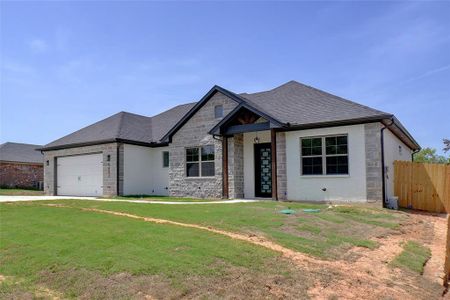 View of front facade featuring a garage and a front yard