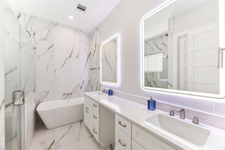 Luxurious spa-like bathroom has a freestanding soaking tub and an oversized shower.