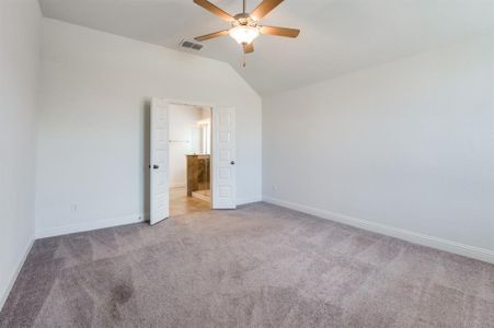 Unfurnished bedroom featuring carpet, ceiling fan, and vaulted ceiling