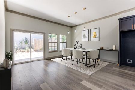 Dining area with ornamental molding and wood-type flooring