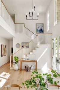 Stairway with french doors, hardwood / wood-style flooring, a towering ceiling, and a notable chandelier