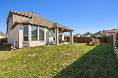 Large backyard with spacious covered patio with outdoor ceiling fan.