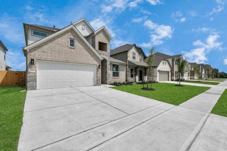 Home showcases a convenient 2-car garage paired with a spacious driveway, providing ample room for parking. Sample photo of completed home with similar plan. As built color and selections may vary.