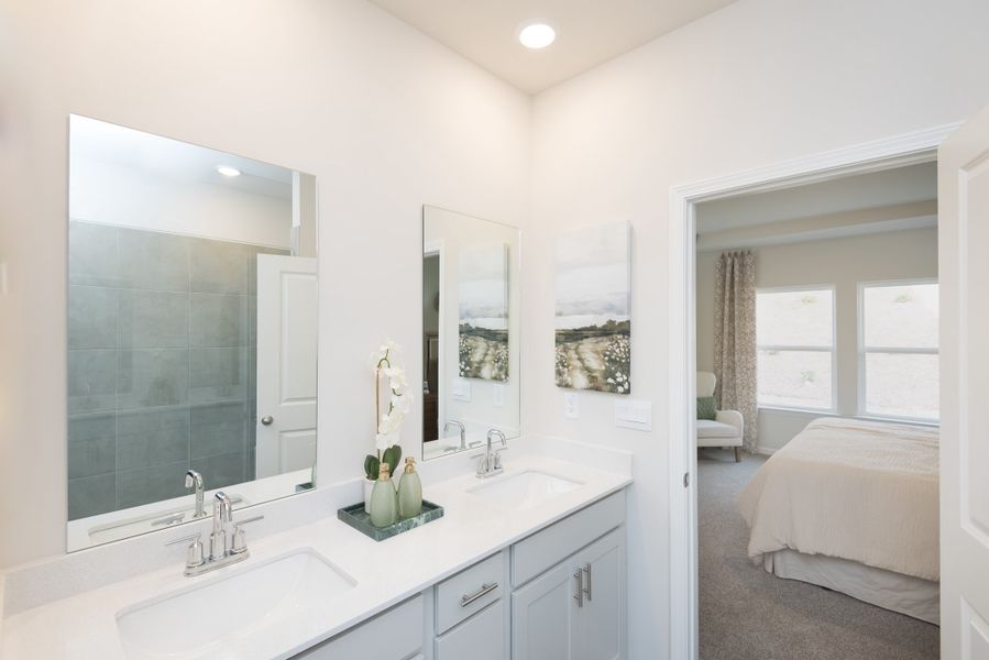 The primary suite boasts dual vanity sinks and a walk-in shower.