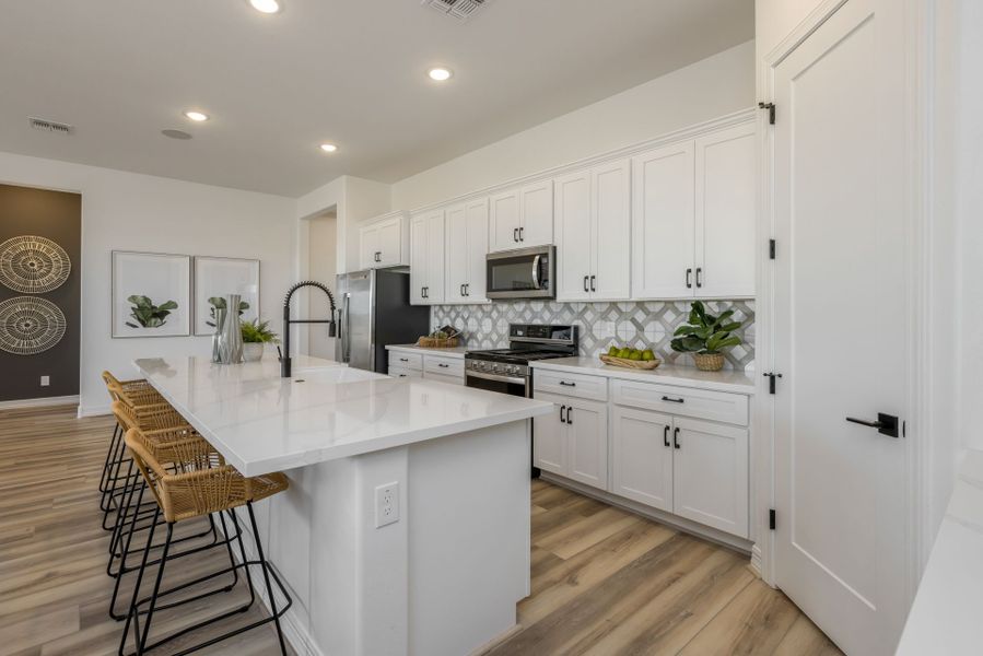 Jimson Floor Plan overall view of modern design kitchen. With walk-in pantry to store goods. New home construction by William Ryan Homes Phoenix