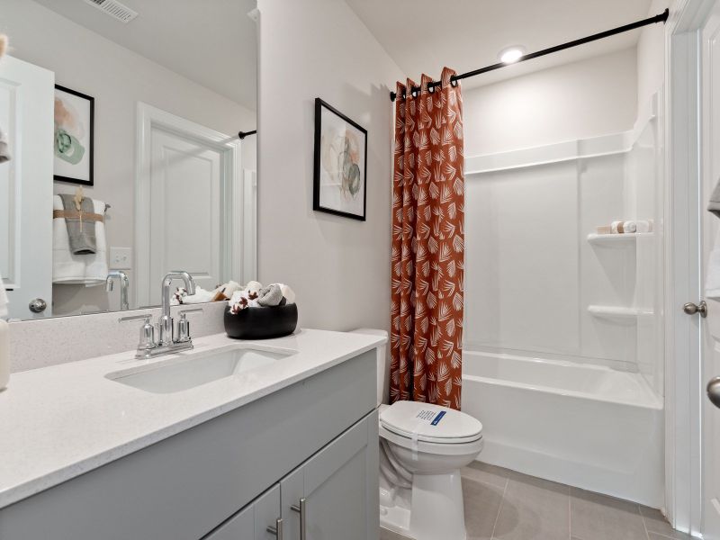The secondary bath offers a space for guests to get ready.