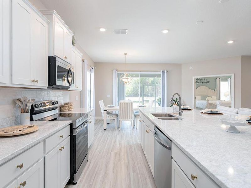 Your dream kitchen includes 36-in. staggered cabinets, Samsung stainless appliances, and a large island - Shelby model home in Lake Alfred, FL
