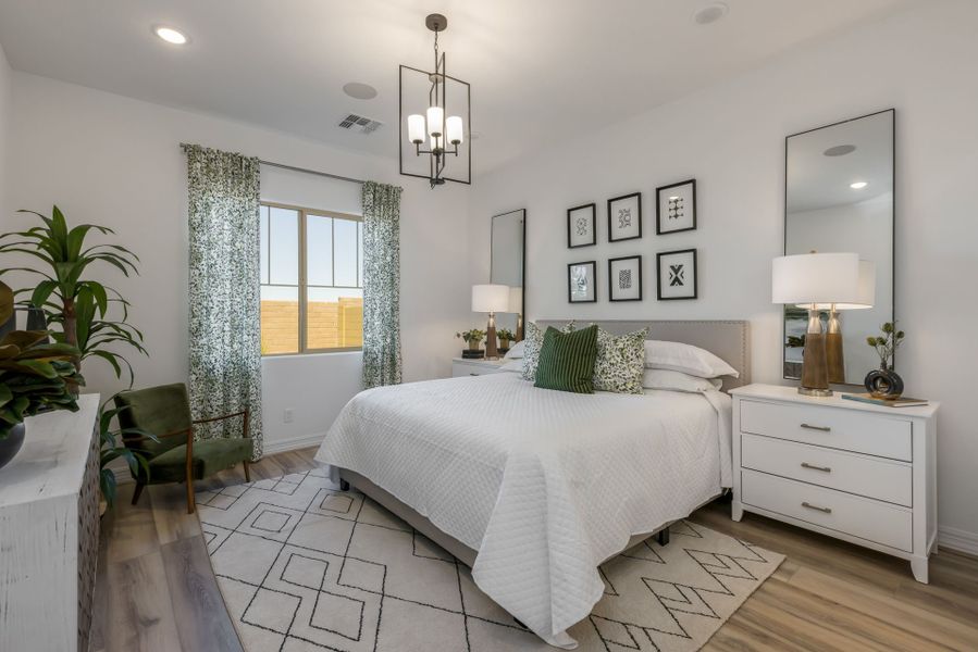 Jimson Owner's Bedroom. Spacious with beautiful touches of white and green. Wood floors. View to backyard new home construction by William Ryan Homes Phoenix