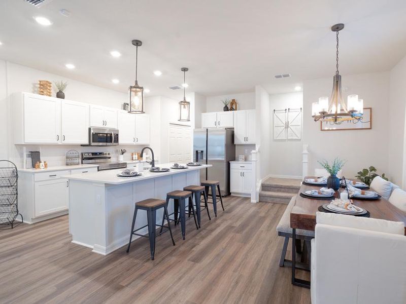 These bungalows feature a well-appointed kitchen with an island, pantry, and Samsung appliances - Aria model home in St. Cloud, FL