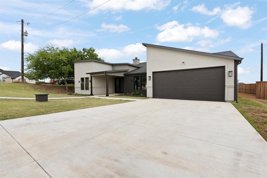 View of front of house with a garage and a front lawn