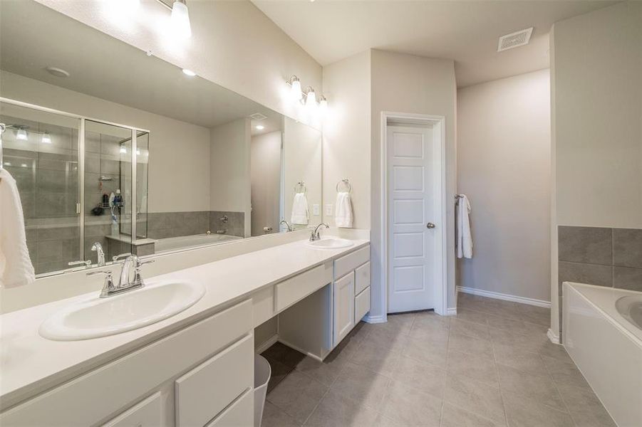 Bathroom with vanity, separate shower and tub, and tile patterned floors