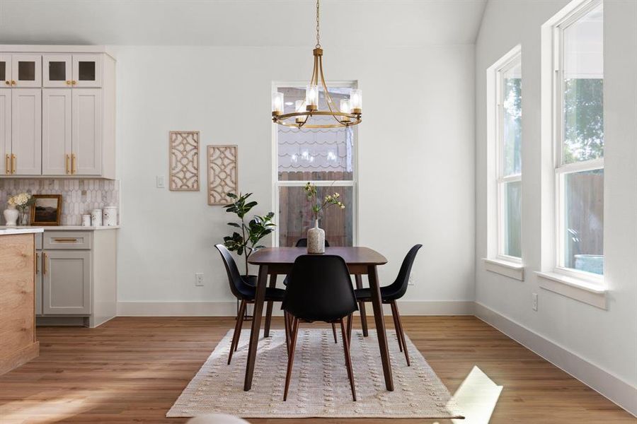 Dining room with a notable chandelier, light hardwood / wood-style flooring, and a wealth of natural light