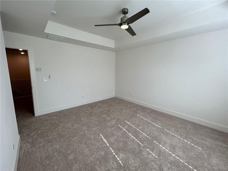 Carpeted spare room featuring ceiling fan