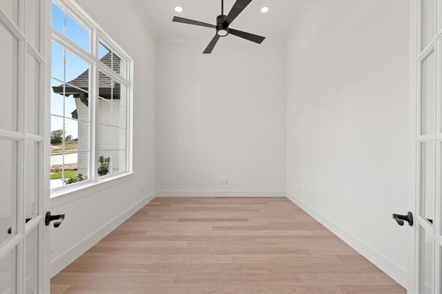 Empty room featuring ornamental molding, ceiling fan, and light hardwood / wood-style floors