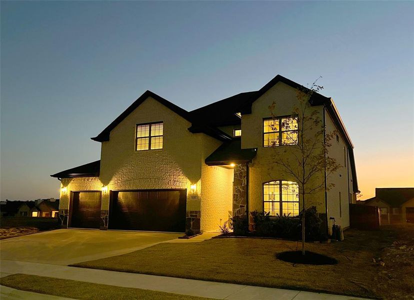 View of front of property with a yard and a garage