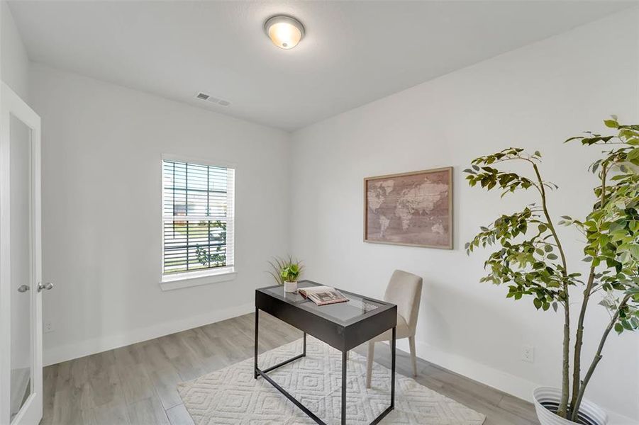 Office area with light hardwood / wood-style floors