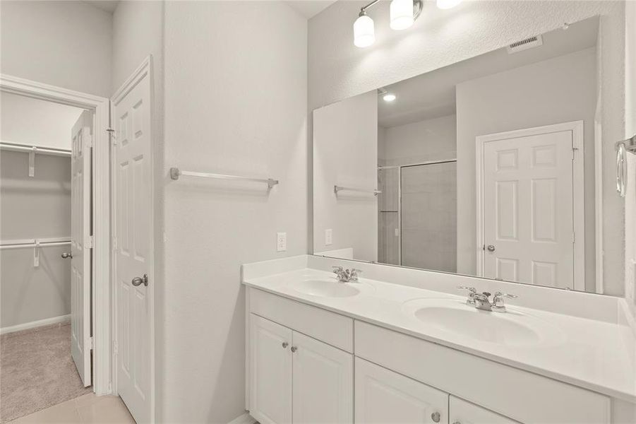 The en-suite bathroom offers a spa-like atmosphere with its elegant design, high end finishes, and tasteful lighting, creating a retreat within your own home.