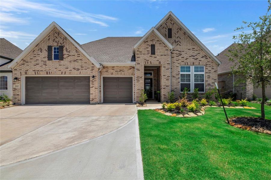 Stunning Exterior - Expansive driveway accommodates multiple vehicles, leading to a 3-car garage. This beautiful brick home, built in 2023, features a meticulously landscaped yard, offering new-home luxury feel and curb appeal.