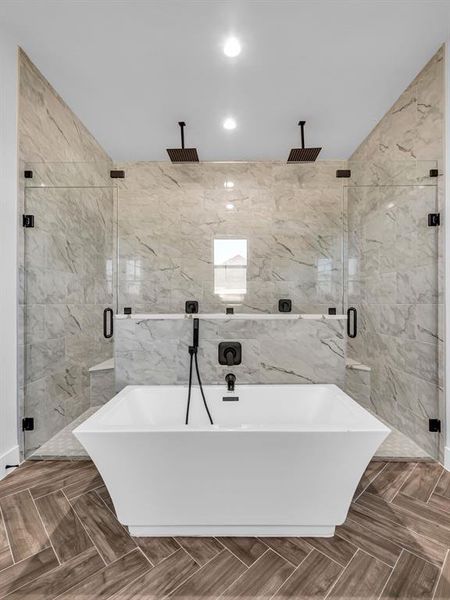 Bathroom featuring parquet floors, plus walk in shower, and tile walls