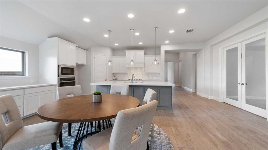 Dining area with light wood-type flooring, french doors, and sink