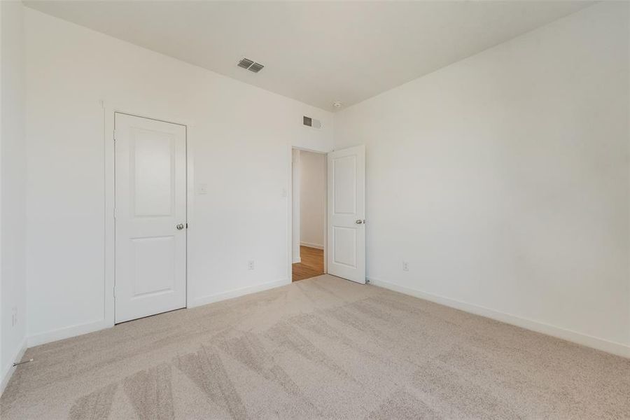 Unfurnished bedroom with light colored carpet