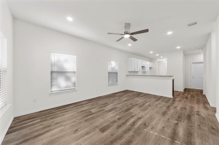 Unfurnished living room with ceiling fan and hardwood / wood-style floors