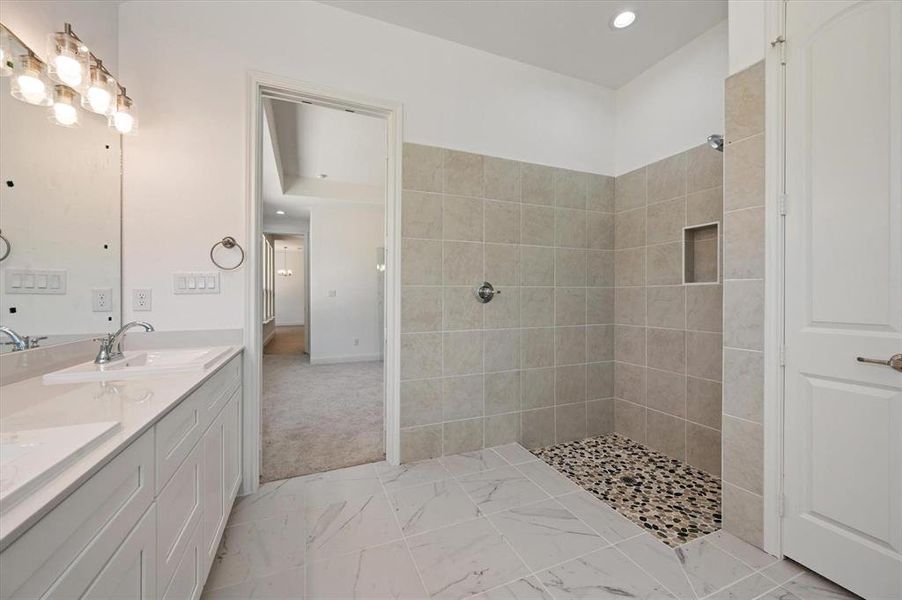 Bathroom featuring vanity and tiled shower