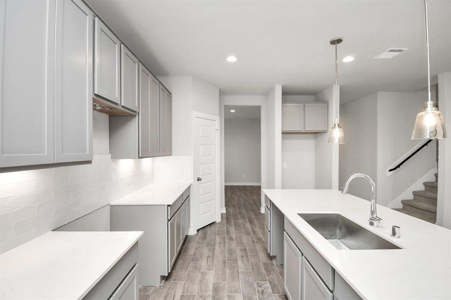 Discover another perspective of this stunning kitchen, generously appointed with an abundance of counter space. Sample photo of completed home with similar floor plan. As-built interior colors and selections may vary.