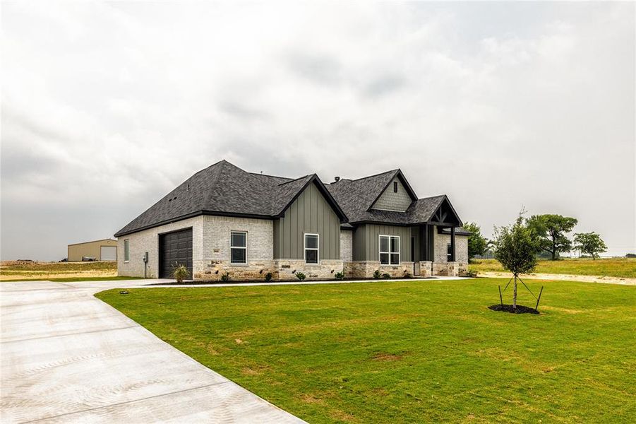 View of front of house featuring a garage and a front lawn