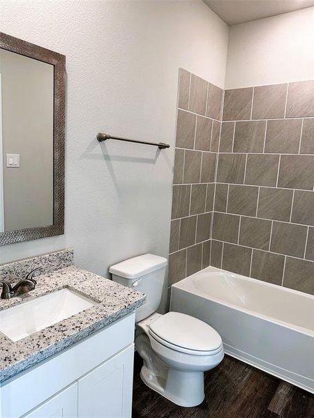Bath 2 features a stylish framed mirror, granite counters, ceramic tile bath tub walls.