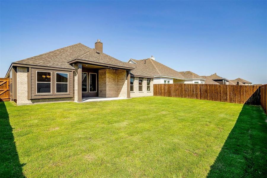 Rear view of property featuring a yard and a patio