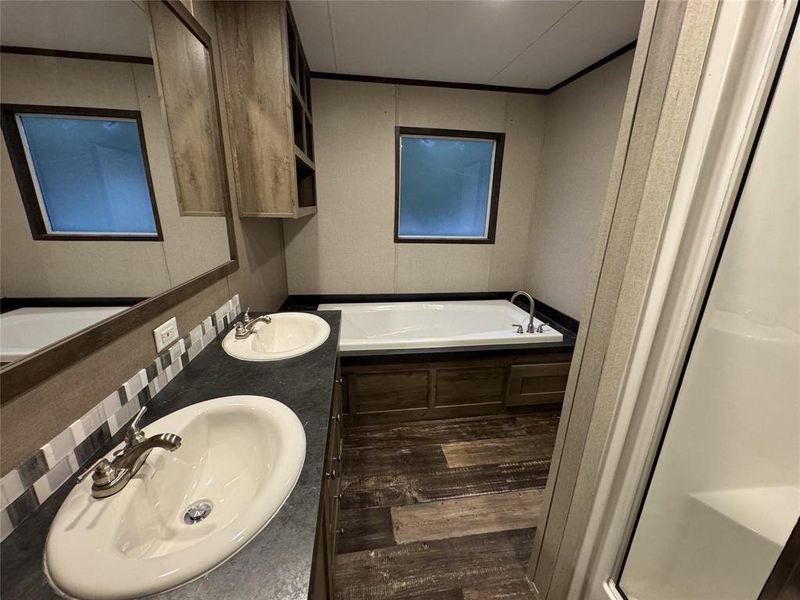Bathroom with a bathtub, hardwood / wood-style floors, and dual bowl vanity