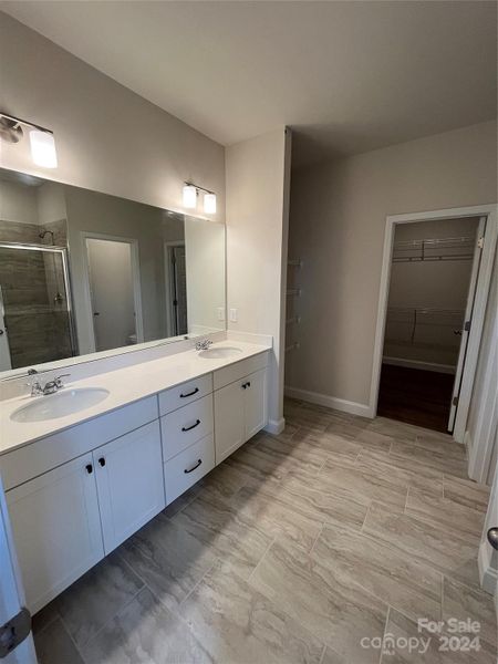 Owner's En Suite Bathroom with dual vanities, quartz countertop and walk-in shower.