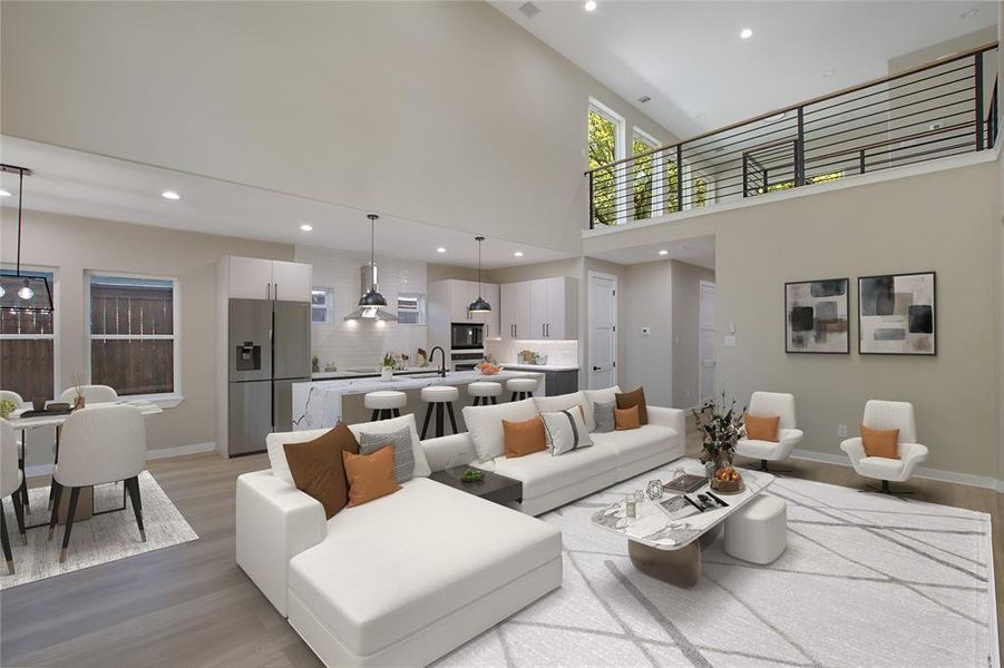 Living room featuring light wood-type flooring, a towering ceiling, and sink