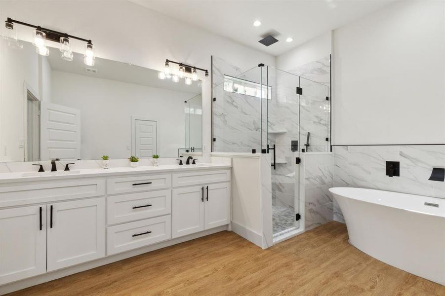 Bathroom featuring shower with separate bathtub, hardwood / wood-style floors, vanity, and tile walls