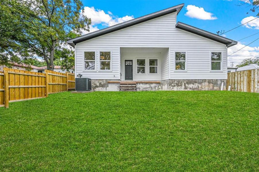 Back of house featuring cooling unit and a yard