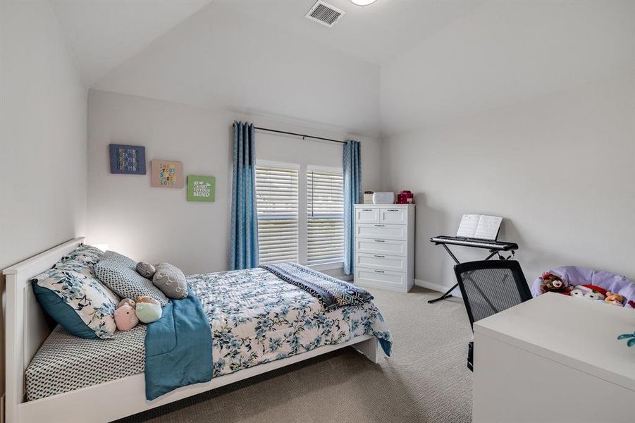 Bedroom with light carpet and vaulted ceiling