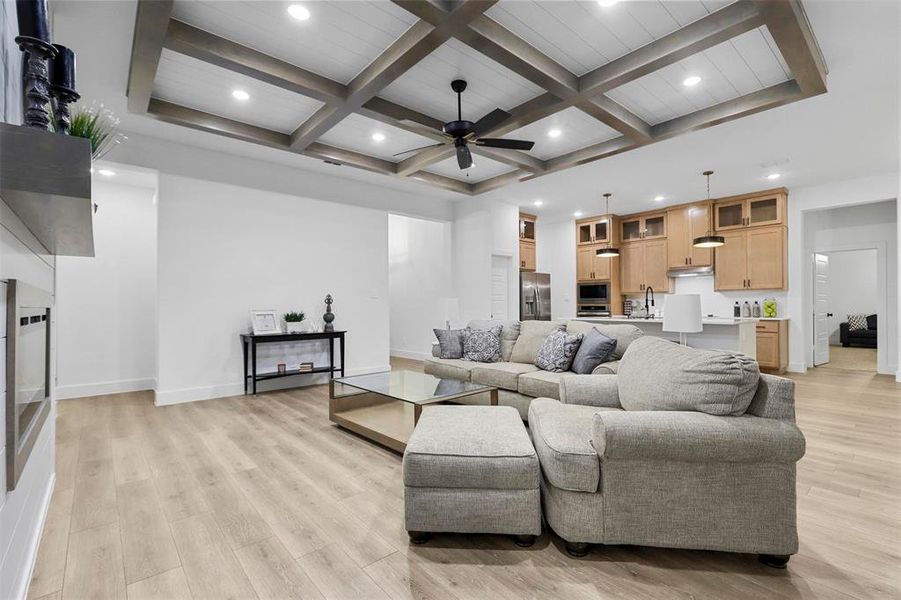 Living room with light hardwood / wood-style floors, beamed ceiling, sink, ceiling fan, and coffered ceiling