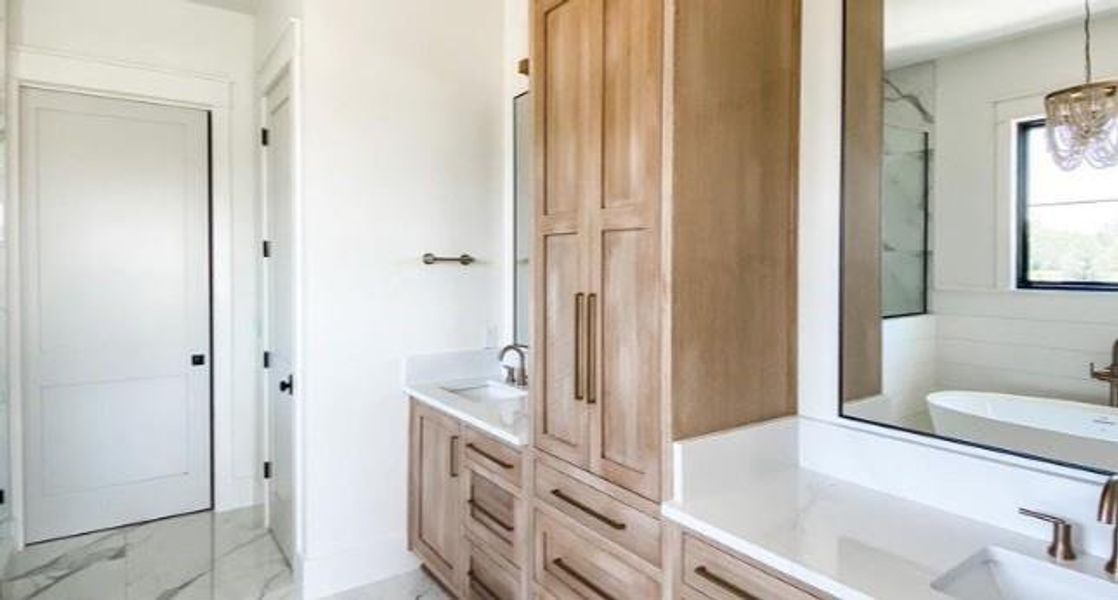 Bathroom with walk in shower, vanity, and a chandelier