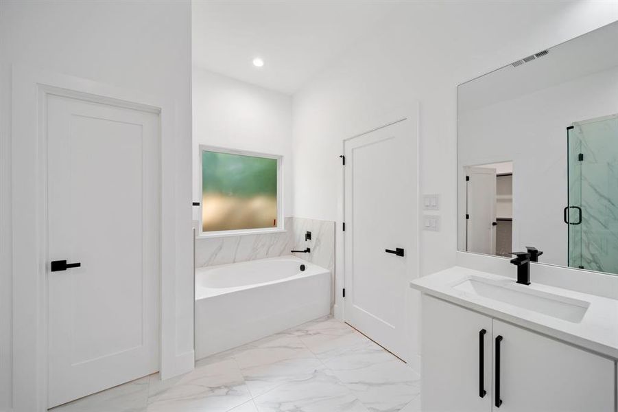 Bathroom featuring vanity and shower with separate bathtub