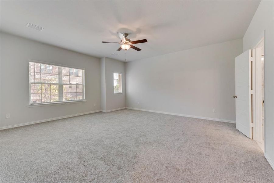 Carpeted empty room with ceiling fan