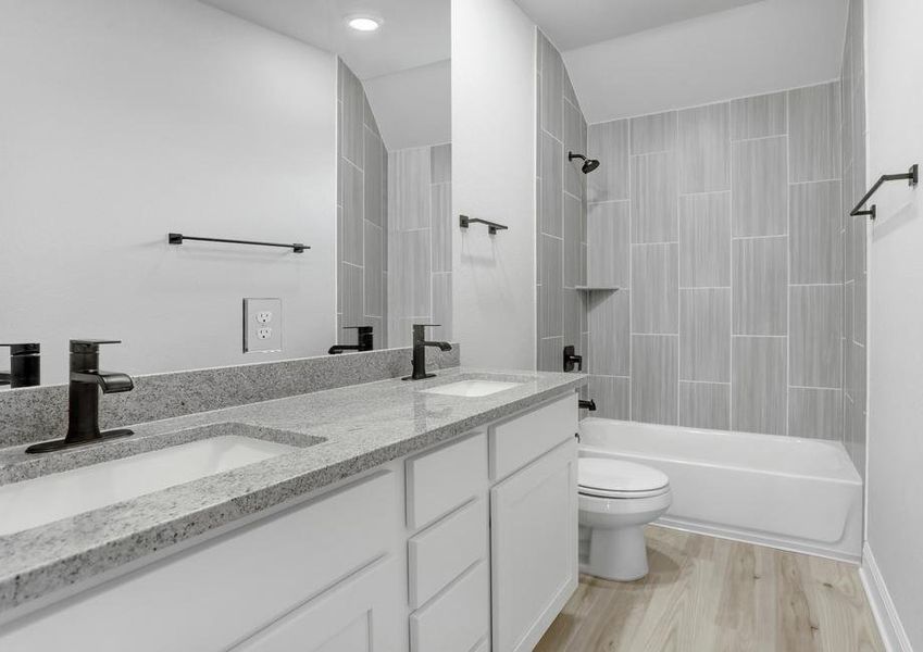 Guest bathroom with dual shower and tub, white cabinets, and granite countertops.