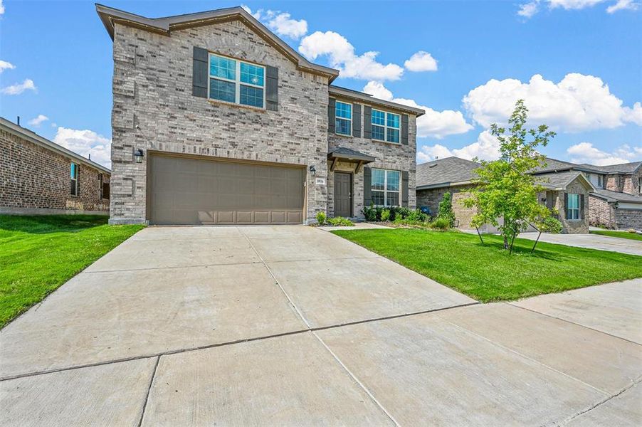 View of front of house with a garage and a front lawn