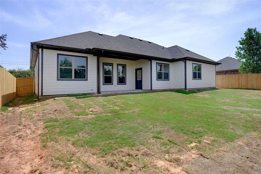 Back of house with a lawn