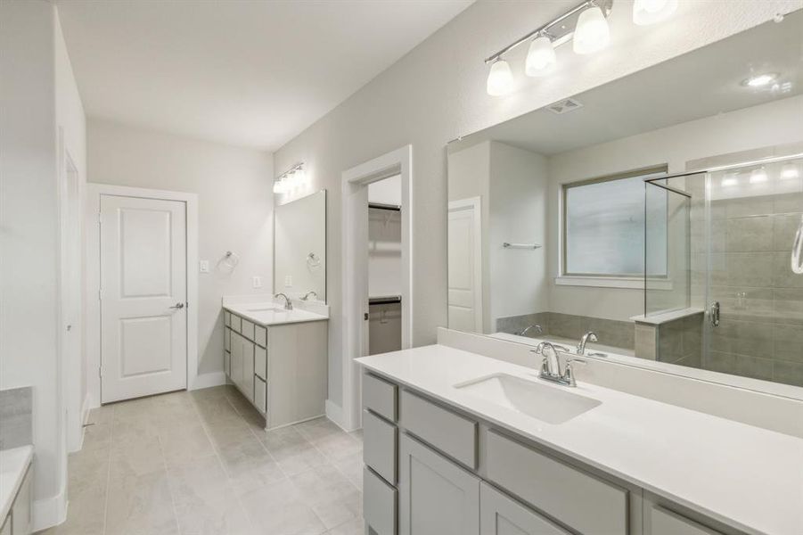 Bathroom featuring tile patterned floors, walk in shower, and vanity