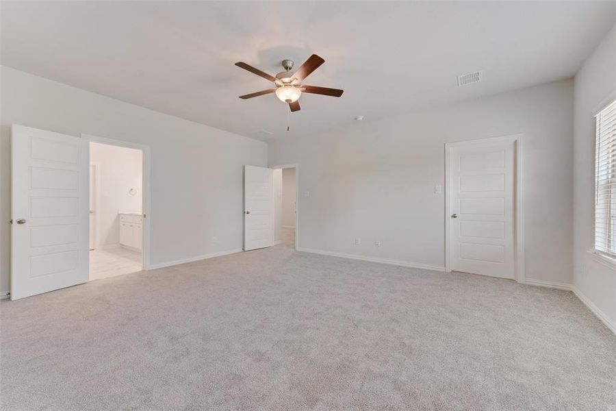 Carpeted empty room with ceiling fan