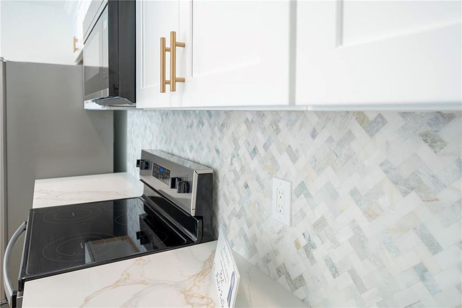 The backsplash blends nicely with the countertops and the hardware on the cabinets.