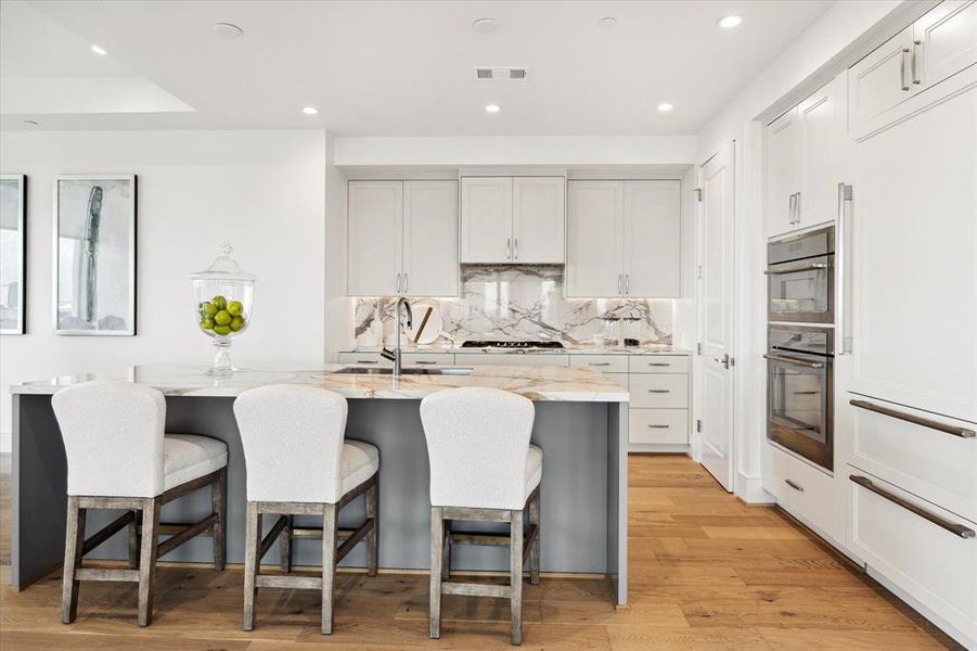 The kitchen has beautiful countertops with matching backsplash, walk-in pantry and Thermador appliances throughout.