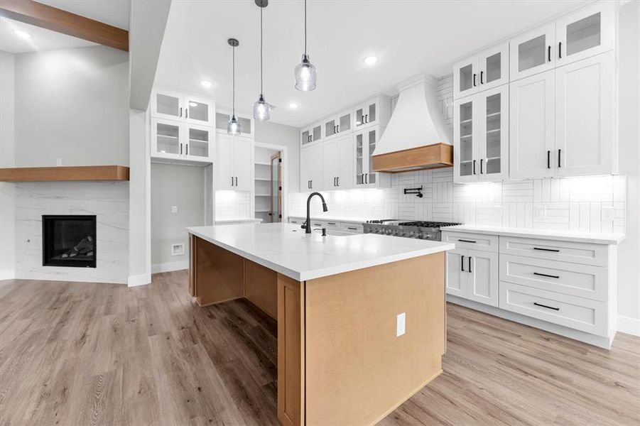 Kitchen cabinetry in soft white and wood tones includes soft-close drawers and cabinets